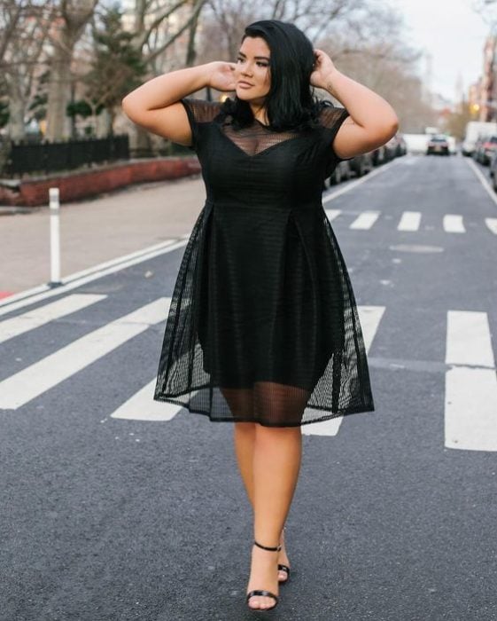 Chica currvy usando un vestido de color negro con transparencias 