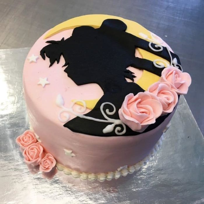 Pastel de Sailor Moon de la silueta del rostro de Serena y algunas rosas de betún decorando alrededor