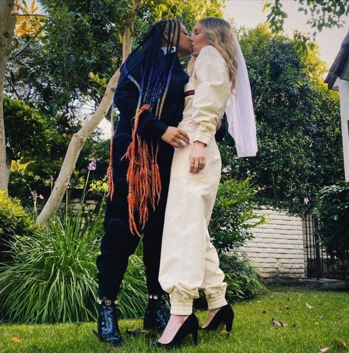 Raven-Symoné y Miranda Maday besándose para celebrar su boda secreta en el patio de su casa 