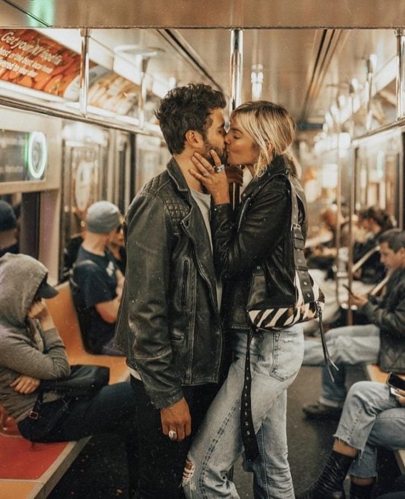 Pareja besándose de pie en el metro