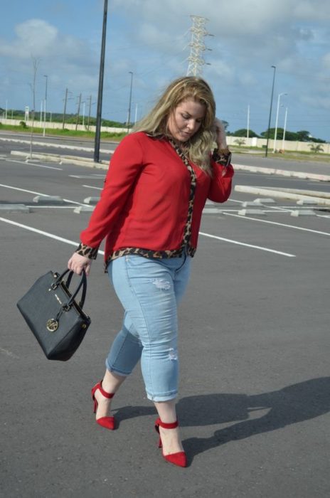 Chica curvy con jeans y blusa y zapatos rojos