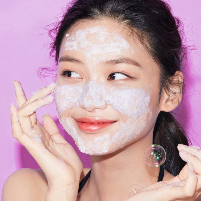 Chica coreana aplicándose una mascarilla