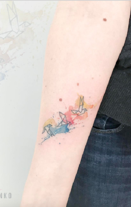tatuaje de grullas con tonos de colores arcoíris