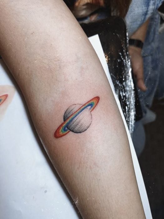 Tatuaje de Saturno con tonos de colores arcoíris