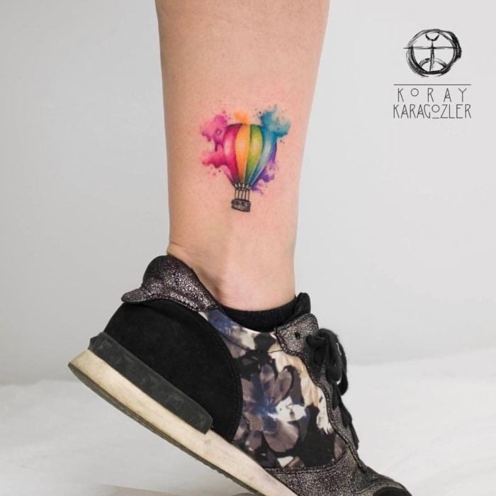 Tatuaje de globo aerostatito con tonos de colores arcoíris