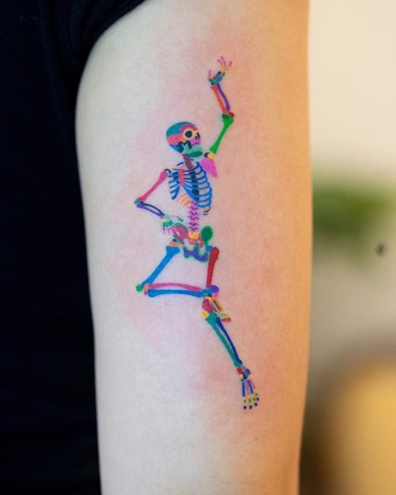 Tatuaje de calavera bailarina con tonos de colores arcoíris