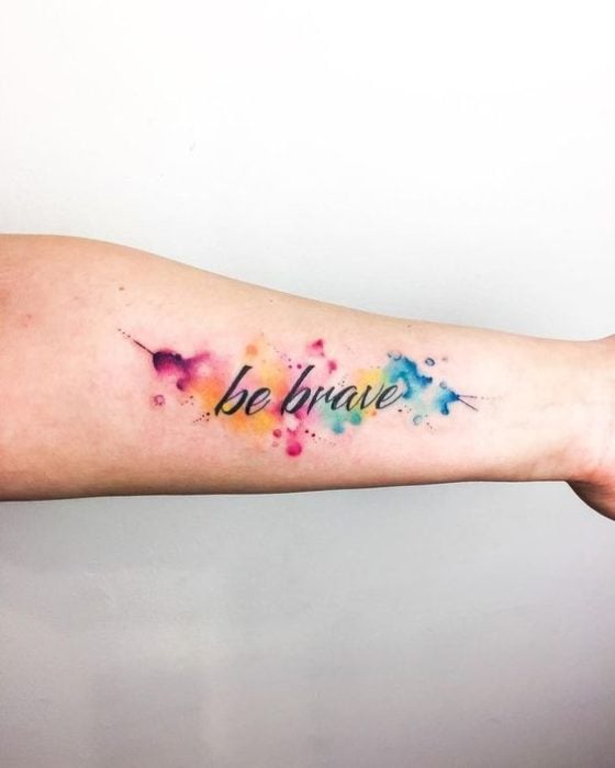 Tatuaje de frase y fondo con tonos de colores arcoíris