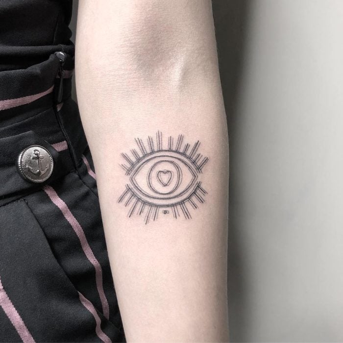 Tatuaje de ilusión óptico de un ojo con pestañas y un corazón como pupila