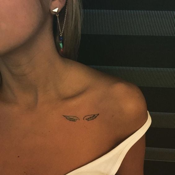 Tatuaje pequeño de alas en clavícula de mujer