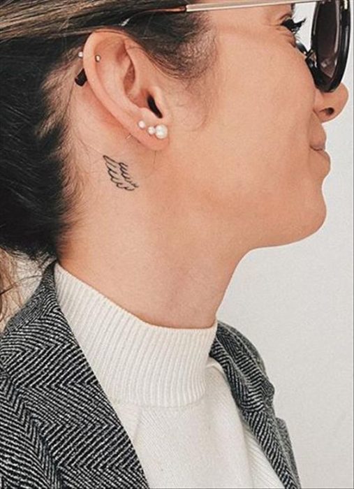 Tatuaje de ala en el cuello de mujer