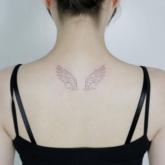 Chica de blusa negra con tatuaje de alas en la espalda