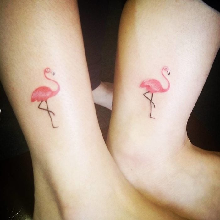 Tatuajes para compartir con tus amigas, antebrazos con tatuajes de flamingos posados cobre una pata en color rosa