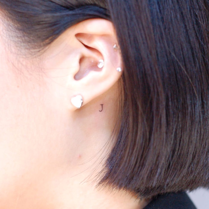 Tatuajes pequeños; minitatuaje de letra detrás de la oreja, perforaciones