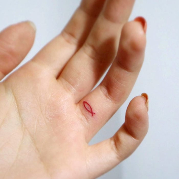 Tatuajes pequeños; minitatuaje de pez en el dedo