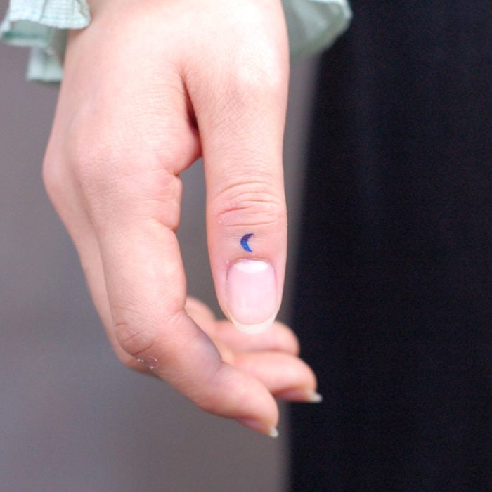 Tatuajes pequeños; minitatuaje de luna azul en el dedo pulgar