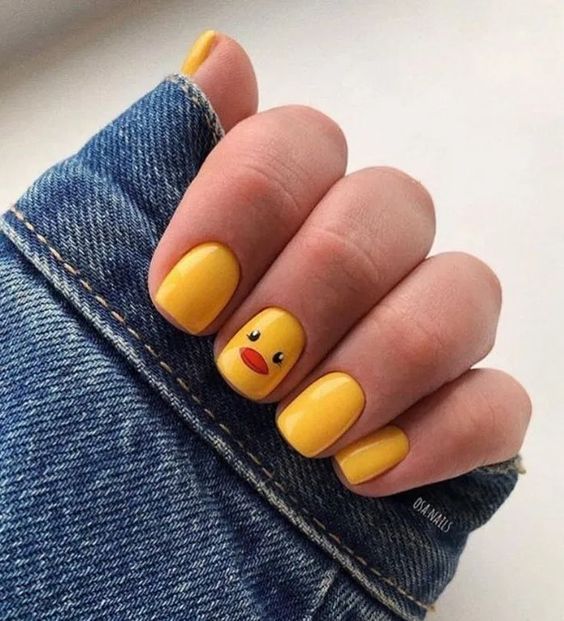 Manicura en color amarillo simulando un pato como decoración
