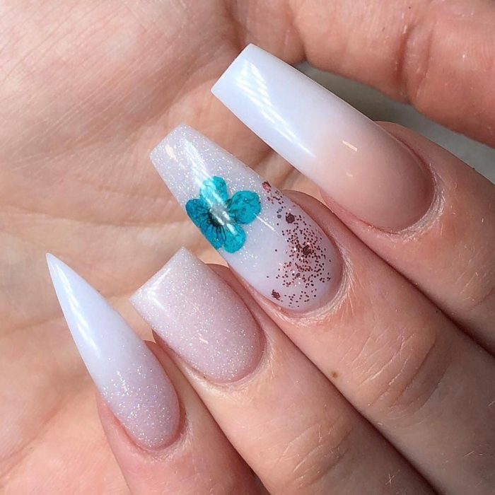 Uñas asimétricas blancas con toques flores