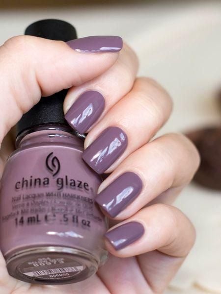 manos de mujer con manicura en tonos violeta grisaseos 