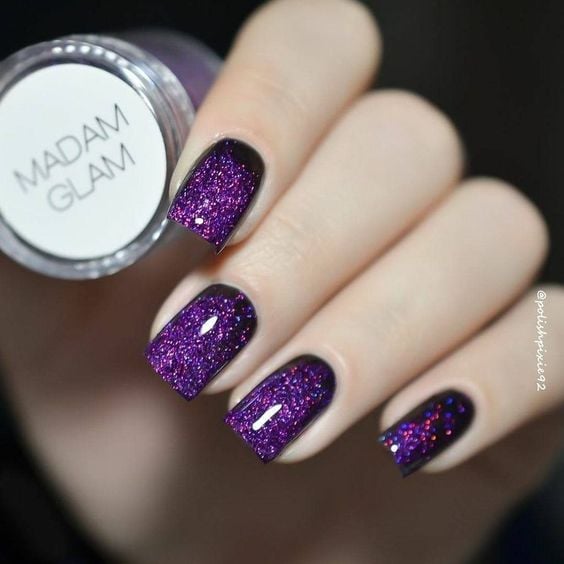 manos de mujer con manicura en tono purpura con efecto glitter 