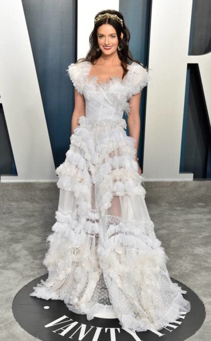 Lydia Hears usando un vestido blanco con encajes durante el after party de los premios oscar 2020 
