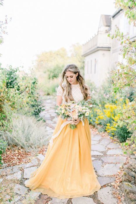 Novia con vestido blanco en la parte superior y amarillo en la parte inferior