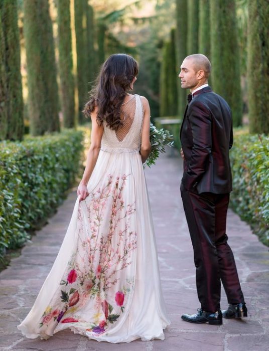 Novia con vestido blanco con la parte trasera con flores