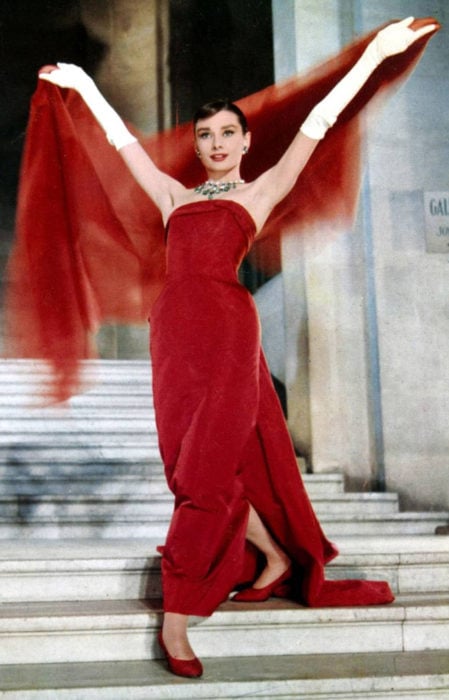 Audrey Hepburn en Funny Face bajando las escaleras mientras presume su hermoso vestido de color rojo y su chalina 