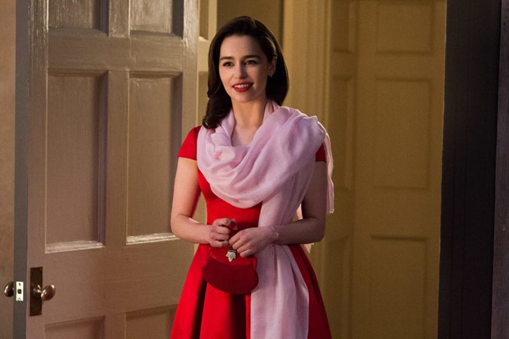 Emilia Clarke usando un vestido de color rojo con una chalina rosa durante la película Yo antes de ti 