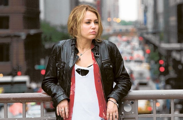 Miley Cyrus en la película Lol: casi 18 usando una chaqueta de cuero con blusa blanca 
