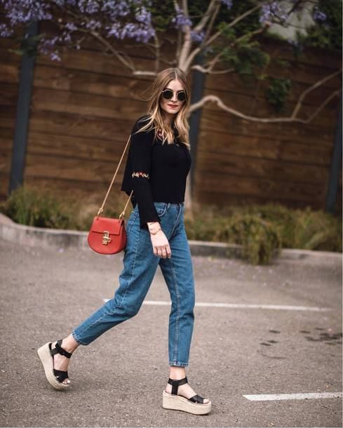 Chica con outfit de mezclilla., blusa negra y zapatos wedges