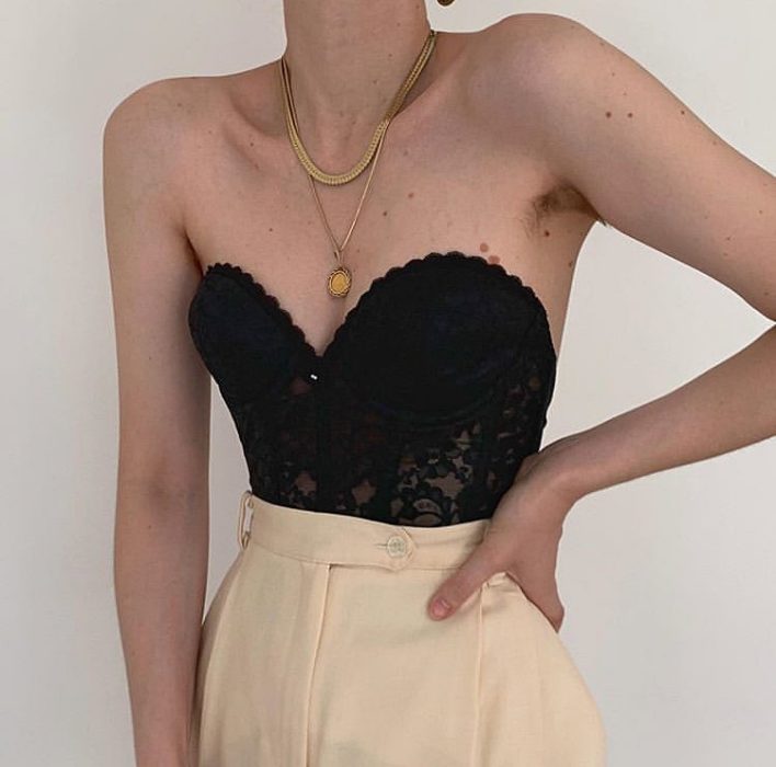 chica usando bustier negro con pantalones de vestir a la cintura color beige