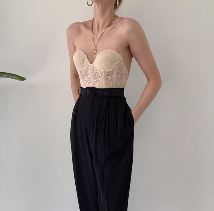 chica usando bustier de color beige y pantalones de vestir negros a la cintura