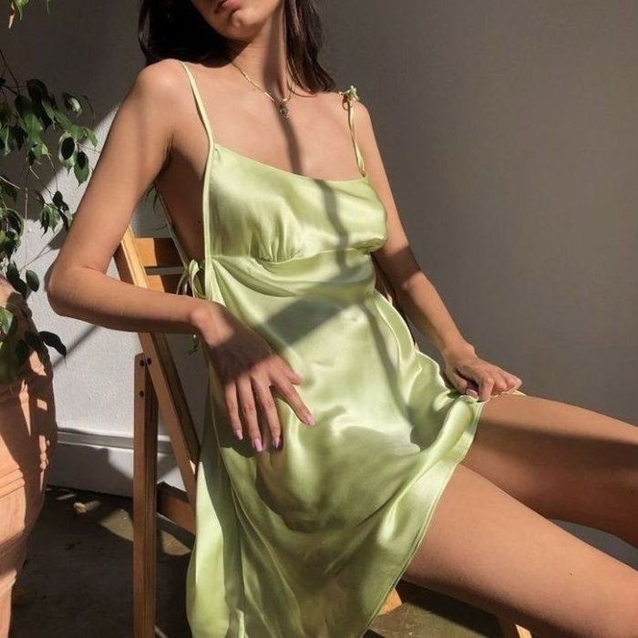 chica con vestido de satén, satin dress de tirantes sentada en una silla