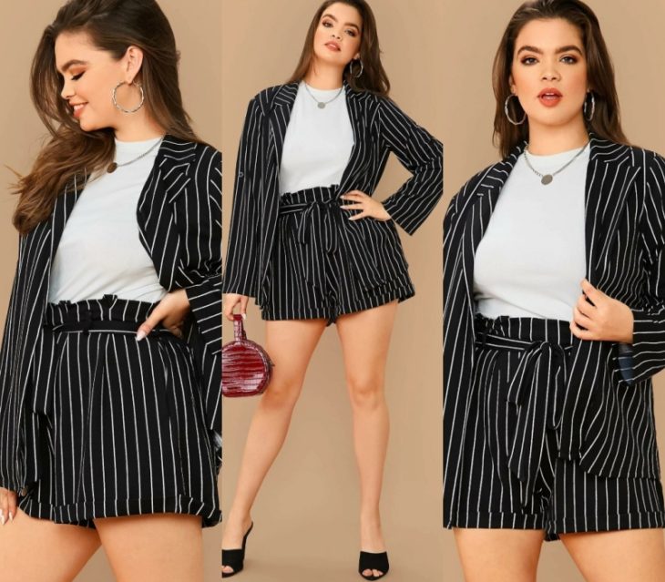 chica curvy con cabello castaño claro largo, usando un conjunto de short y blazer negros con lineas blancas, top blanco y tacones negros