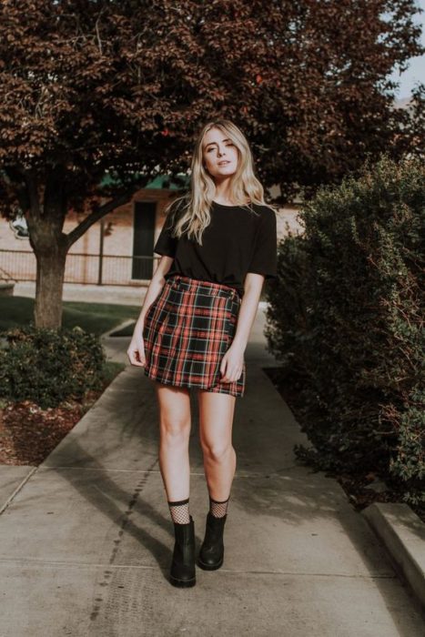 chica con skort y playera negra, tenis y calcetines