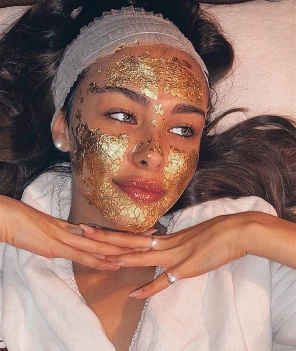 Chica llevando una mascarilla dorada con grenetina