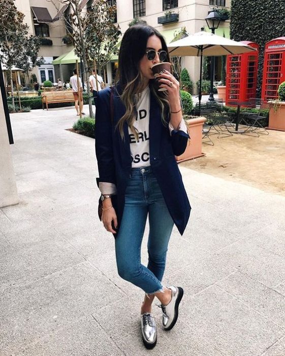 Chica usando blazer azul marino, zapatos plateados y jeans de tiro alto