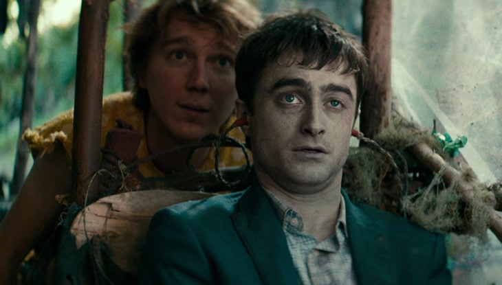 Daniel Radcliffe en la película Un cadáver para sobrevivir, sentado en medio de la selva