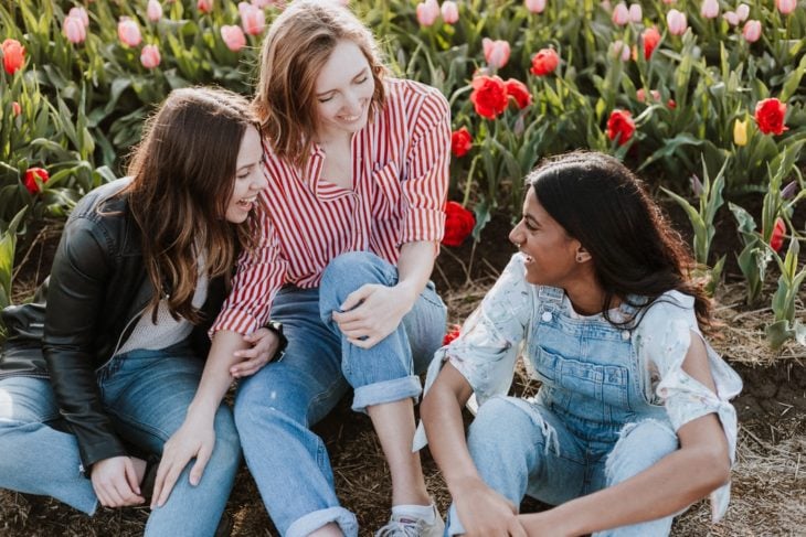 Grupo de amigas charlando y riendo en un campo de tulipanes