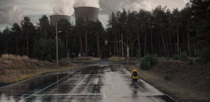 Escena de la serie Dark, Jonas paseando en bicicleta cerca de la planta nuclear