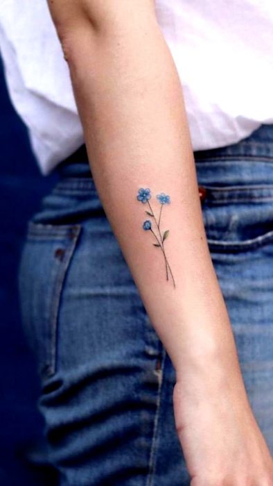 Tatuaje con una flor azul de tallos largos