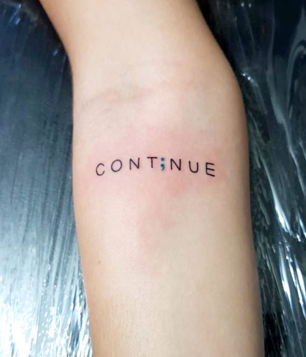 Tatuaje con la palabra continuar en inglés, Continue