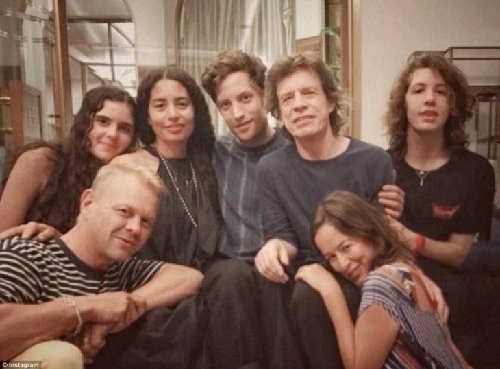 Mick Jagger junto a sus seis hijos sentado en un sofá