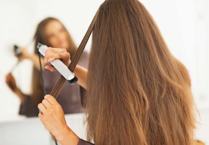 Chica planchando su cabello