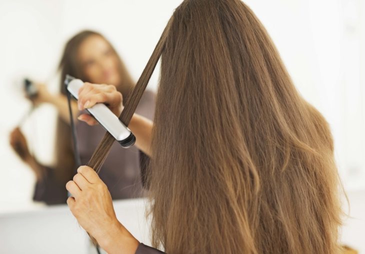 Chica planchando su cabello