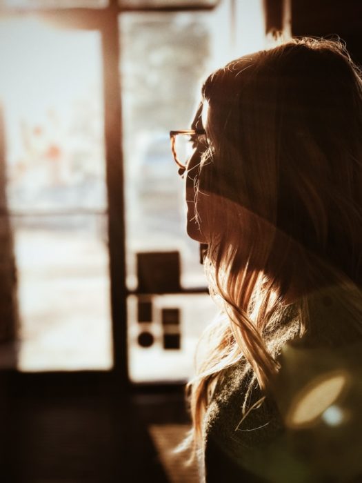 Chica usando lentes con luz del sol sobre su rostro