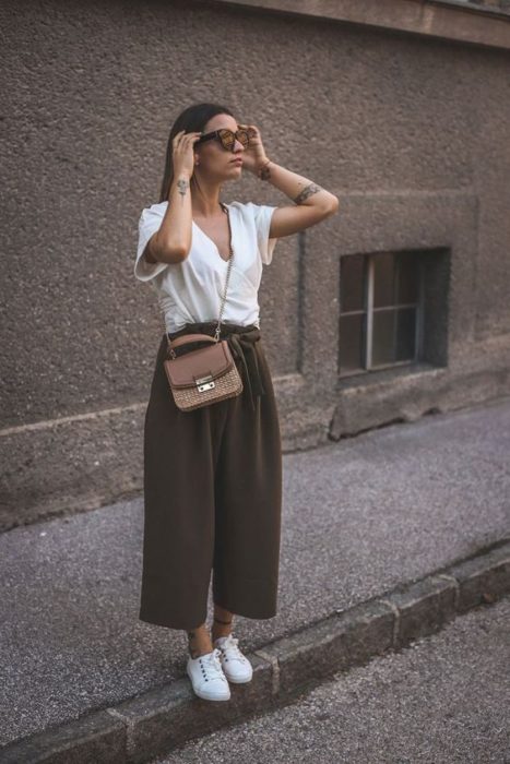 Chica usando paper pants, playera blanca y tenis blancos