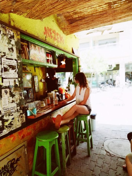 Mujer sentada en la barra de un bar