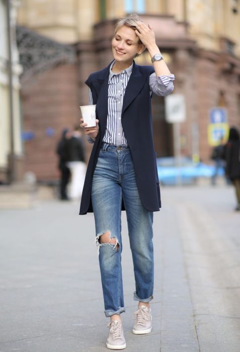 Chica usando pantalones rectos, con tenis y camisa de rayas y un chaleco largo