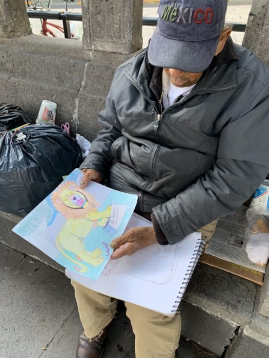Don Baldemar, abuelito mostrando sus dibujos para vender y sobrevivir ante pandemia